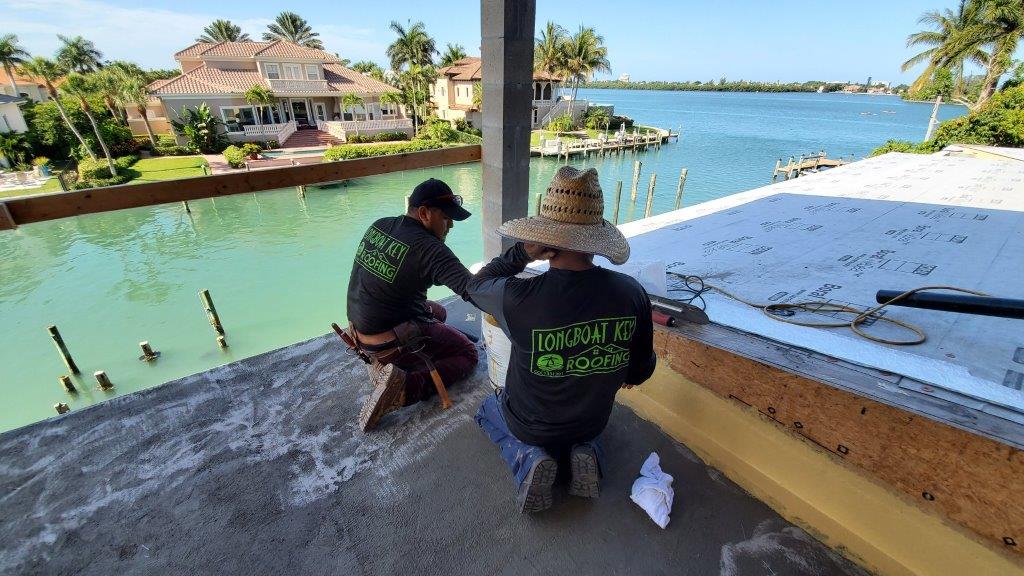 crew on roof near edge of water